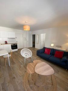 uma sala de estar com um sofá azul e uma mesa em COSY CONFORT LA PEROUSE 1A coeur de ville et plage em Concarneau