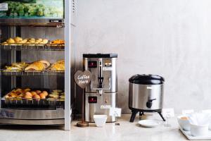 a bakery with a coffee maker and pastries on a counter at Cris Hotel in Florianópolis