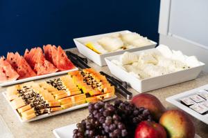 a table topped with different types of cheese and fruit at Cris Hotel in Florianópolis