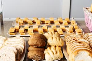 a table topped with trays of bread and pastries at Cris Hotel in Florianópolis