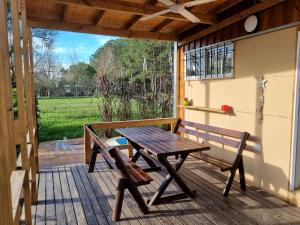 een houten tafel en bank op een veranda met een raam bij Cabaña La Querida in Santa Rosa