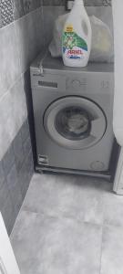 a washing machine with a bottle of detergent on top of it at مدينتي in Madinaty