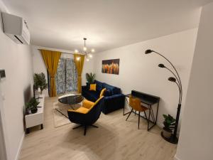 a living room with a blue couch and chairs at Apartments SORELLE in Podstrana