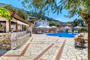 a resort with a swimming pool and a restaurant at Ourania Studios & Apartments in Skopelos Town