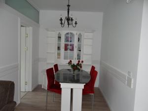 a dining room with a glass table and red chairs at Apartament de lux white&red in Suceava