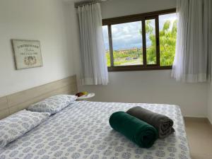 Un dormitorio con una cama con una almohada verde. en Apartamento em Condominio de Luxo - Iberostar- Praia Do Forte, en Praia do Forte
