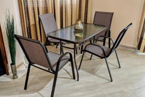 a dining room table with four chairs and a vase on it at Beachfront Apartment in Nea Moudania