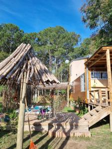 un patio trasero con una casa de madera y un parque infantil en Cabaña La Querida en Santa Rosa