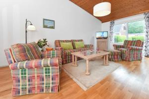 ein Wohnzimmer mit 2 Sofas und einem Tisch in der Unterkunft Ferienhaus Leuchtfeuer in Bensersiel
