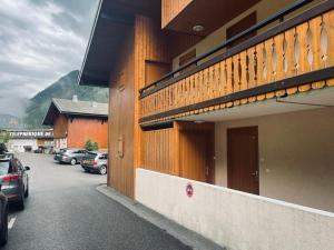 Un edificio con coches aparcados en un estacionamiento. en Le Chamois, en Morzine