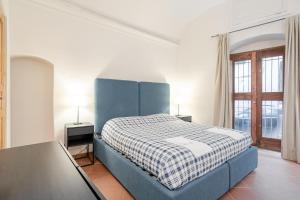 a bedroom with a blue bed and a window at Residenza de Gemmis in Altamura