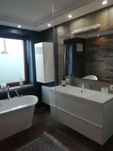 a bathroom with a tub and a large mirror at Mrągowo Pokoje Apartament in Mrągowo