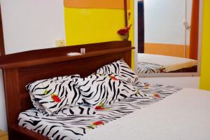 a bedroom with a bed with a zebra print pillow at Chez mimi in Cotonou