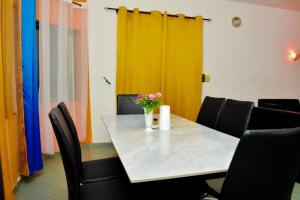 uma mesa com cadeiras e um vaso de flores sobre ela em Chez mimi em Cotonou