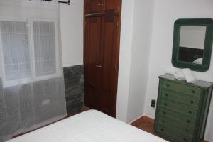 1 dormitorio con tocador verde y espejo en Casa Vacacional El Cañizo en Córdoba