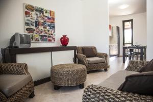 - un salon avec des chaises et une télévision sur une table dans l'établissement Borgomare, à Campofelice di Roccella