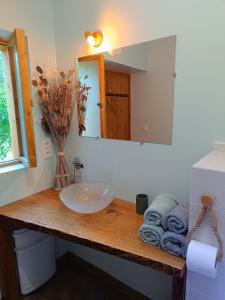 a bathroom with a sink and a mirror and towels at Tente mongole " ô Rêves Atypiques" in Boucé