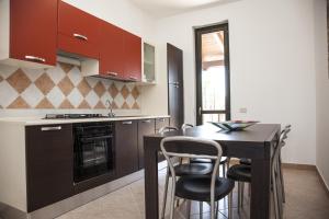 - une cuisine avec une table, des chaises et une cuisinière dans l'établissement Borgomare, à Campofelice di Roccella