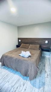 a bedroom with a bed with two white shirts on it at Antu Mahuida Apartments in San Carlos de Bariloche