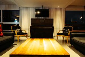 a living room with a piano and chairs at Cris Hotel in Florianópolis