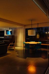 a living room with a table and chairs and a television at Cris Hotel in Florianópolis