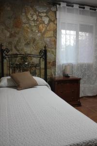 a bedroom with a bed and a stone wall at Casa Vacacional El Cañizo in Córdoba