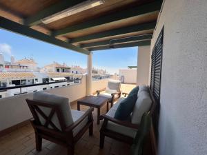 einen Balkon mit Stühlen und eine Couch auf dem Dach in der Unterkunft Almadraba Suite Ático duplex in Zahara de los Atunes