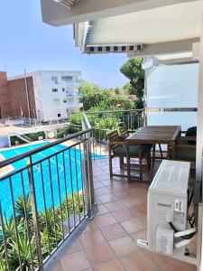 uma varanda com uma mesa e uma piscina em Apartamento familiar con piscina y ubicación ideal em Platja d'Aro