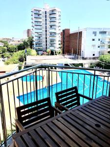 uma varanda com 2 cadeiras e uma piscina em Apartamento familiar con piscina y ubicación ideal em Platja d'Aro