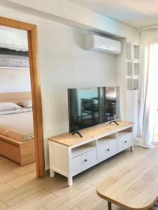 uma sala de estar com televisão e uma cama em Apartamento familiar con piscina y ubicación ideal em Platja d'Aro