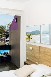 a bedroom with a bed and a view of the ocean at Cris Hotel in Florianópolis