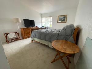 a bedroom with a bed and a couch and a table at Ploy in Monterey Park