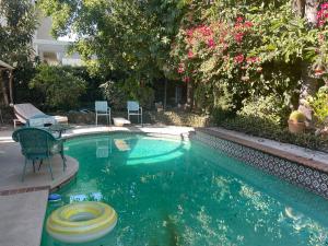 a swimming pool with a table and chairs in a yard at Ploy in Monterey Park