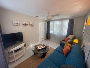 a living room with a blue couch and a tv at St Pete Vacation Rentals in St Petersburg