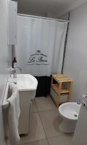 y baño con lavabo, aseo y cortina de ducha. en Cálido depto 2 personas- Zona residencial en Morón