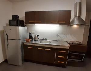 a kitchen with a white refrigerator and a sink at Cálido depto 2 personas- Zona residencial in Morón