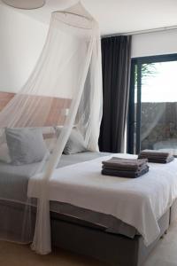 a bedroom with a bed with a mosquito net at Casa Mila with heated pool in El Roque in El Cotillo +19 photos