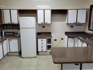 a kitchen with a white refrigerator in the middle at Hostel BoituVillage in Boituva