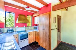 a kitchen with red walls and wooden cabinets at Clearview - Lake Tekapo in Lake Tekapo