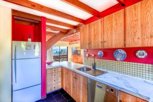 a kitchen with a white refrigerator and wooden cabinets at Clearview - Lake Tekapo in Lake Tekapo