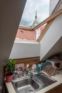 a kitchen sink with a view of a roof at Beethoven Apartment in Bratislava