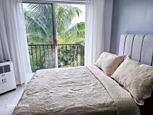 a bedroom with a bed and a large window at Hostel Vistas del Sol-Casa Victoria in San Isidro