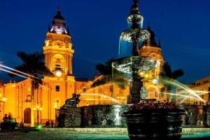 a fountain in front of a building with a clock tower at LOVENEST in Lima