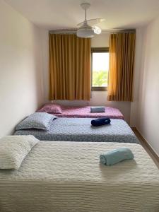 2 camas individuales en un dormitorio con ventana en Apartamento em Condominio de Luxo - Iberostar- Praia Do Forte, en Praia do Forte