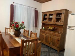 d'une salle à manger avec une table et une armoire en bois. dans l'établissement Casa Vista para Serra, à Tiradentes