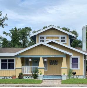 a yellow house with a gray roof at St Pete Vacation Rentals in St. Petersburg