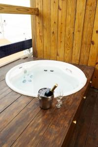a bath tub with a bottle of wine and wine glasses at Cris Hotel in Florianópolis