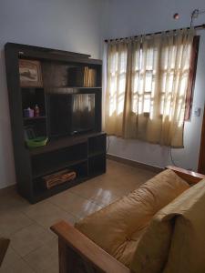 a living room with a couch and a flat screen tv at DON MIGUEL DEPARTAMENTOS in Puerto Iguazú +17 photos