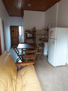 a kitchen with a table and a white refrigerator at DON MIGUEL DEPARTAMENTOS in Puerto Iguazú