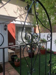 una valla de hierro forjado frente a un patio con macetas en House o' Books en Londres